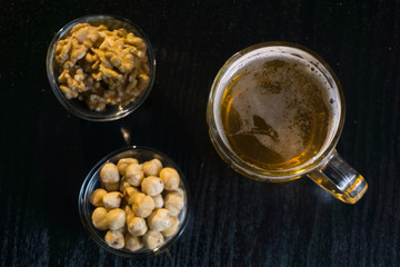 beer on the dark black wood near beer nuts