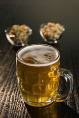 beer on the dark black wood near beer nuts