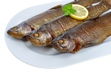 Drei geräucherte Forellen auf weißer, freigestellter Platte - Three smoked rainbow trouts on a white plate isolated on white background