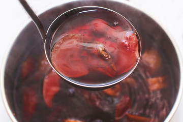 ladle with compote over a pan 