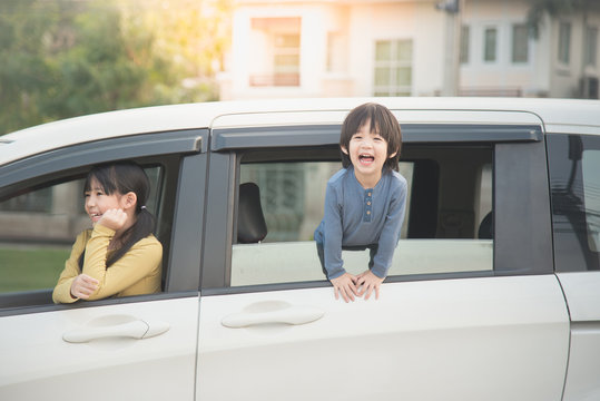 Happy asian children sitting in the car