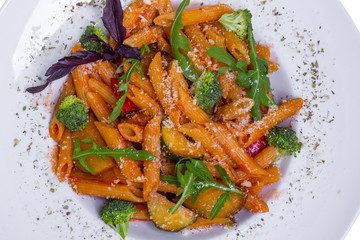 Red penne pasta with tomato sauce and vegetables