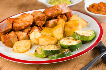 skewered meat and vegetables on wooden plate