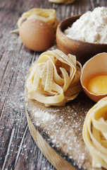 Uncooked pasta with flour on the table, selective focus