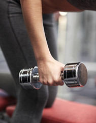 close up of couple with dumbbell exercising in gym