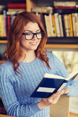 happy student girl reading book in library