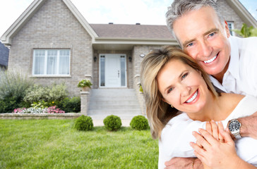 Happy senior couple near new house.