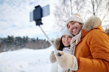 happy couple taking selfie by smartphone in winter