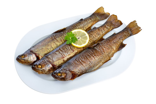 Drei ger&auml;ucherte Forellen auf wei&szlig;er, freigestellter Platte - Three smoked rainbow trouts on a white plate isolated on white background