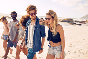 Happy friends having a walk on the beach - Powered by Adobe