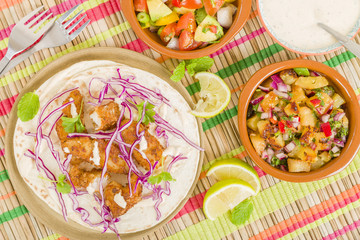 Baja Fish Tacos - Soft shell tacos filled with seasoned fried white fish served with red cabbage, pineapple salsa, chunky guacamole and creamy Baja style sauce.
