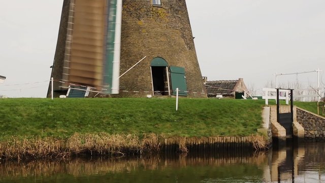 Sails passing lower part of Dutch windmill, Unesco World Heritage Site Kinderdijk, South Holland, The Netherlands