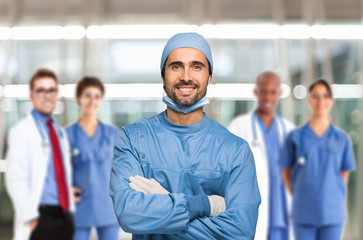 Smiling surgeon in front of his team - obrazy, fototapety, plakaty