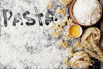Uncooked pasta with flour on the table, selective focus