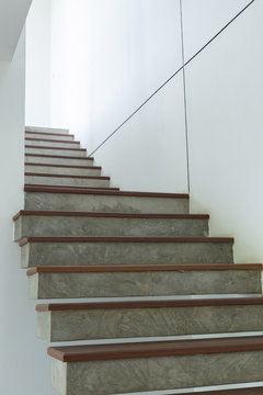 cement and wood staircase on white mortar wall