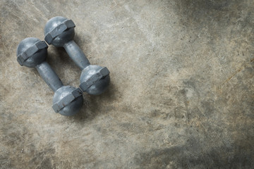 metal dumbbell on cement floor, fitness sport of bodybuilding