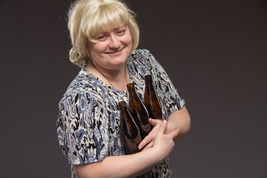 Female alcoholism. Lonely poor fat woman aged drinking beer and