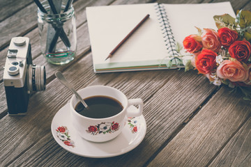 Vintage Film Look: cup of coffee with camera and notebook