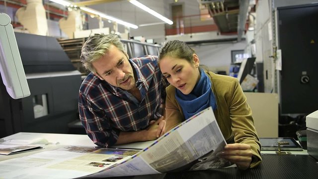 Man in printing house showing client proof documents