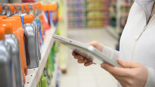 Merchandiser checking products available with digital tablet