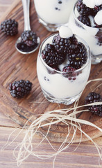 yogurt cup with blackberry on wooden table