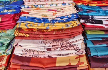 Selection of colourful oilcloths, stacked on a french, local market, Provence, France