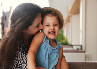 Happy joying kid girl embracing with beautiful mother on summer