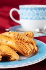 Puff pastry with sesame seeds on a blue cup.