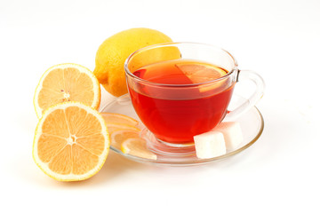 Glass cup of tea near several lemons.