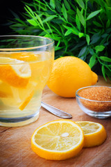 Fresh water with lemon slices on a scratched wooden table
