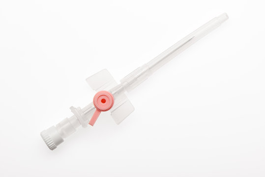 Pink plastic catheter with needle closed by protective cap