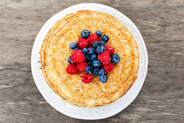 Fresh golden pancakes with raspberries, blueberries