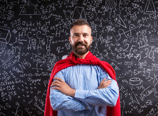 Teacher in red cape against big blackboard with mathematical sym