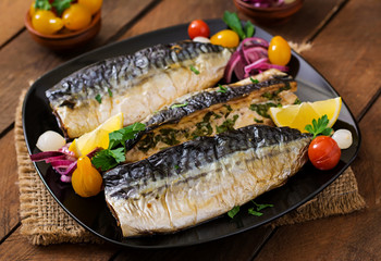 Baked mackerel with herbs and garnished with lemon and pickled vegetables