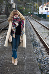 Young adult woman in casual fashion on train tracks