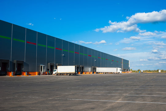 Trucks at big industrial warehouse building