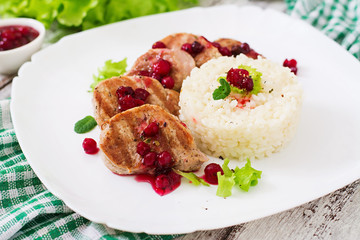 Pork medallions steak with cranberry sauce and a side dish of rice