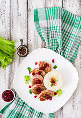 Pork medallions steak with cranberry sauce and a side dish of rice. Top view
