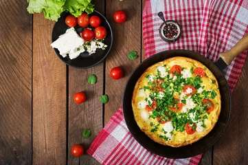 Papier Peint photo Lavable Oeufs sur le plat Omelet with tomatoes, parsley and feta cheese in pan. Top view