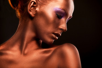 Gilt. Golden Woman's Face Closeup. Futuristic Gilded Make-up. Painted Skin bronze.