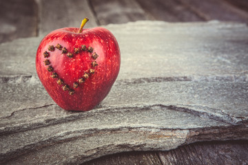 Valentines Day card - red apple with heart on stone background. Instagram colored toning