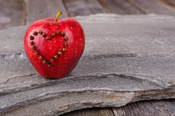Valentines Day card - red apple with heart on stone background