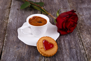 Valentines Day card - Cookies with heart and cup of coffee, red rose at old wooden background
