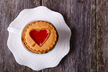 Valentines Day card - Cookies with heart and cup of coffee, at old wooden background. Top view.