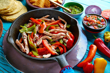 chicken fajitas in a pan chili and sides Mexican