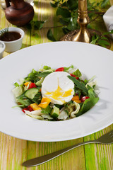 salad with poached egg, cucumbers, arugula, cabbage, peppers, still life on a wooden table green chalkboard pretty food