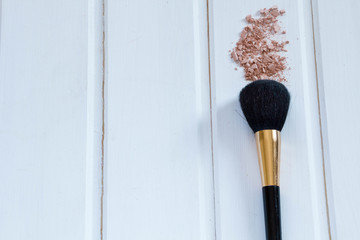 women's accessories cosmetics. Makeup brushes and crushed eyeshadow on wooden background, place for...