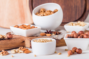 almonds, walnuts, hazelnuts cashews and pine nuts in wooden bowl