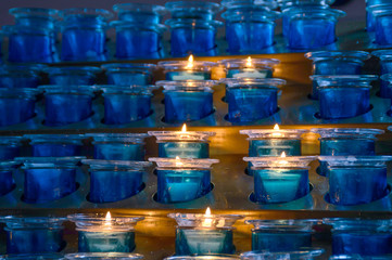 Dark artistic blue glass votive candles with selective focus and - obrazy, fototapety, plakaty