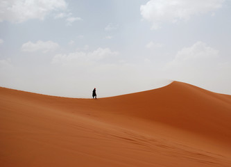 Fototapeta na wymiar Lonely figure in windy Sahara 